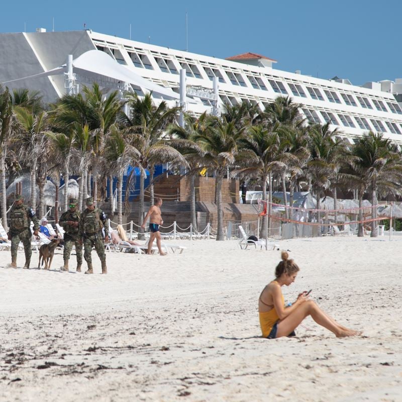 Police patrolling cancun beach with k9 unit