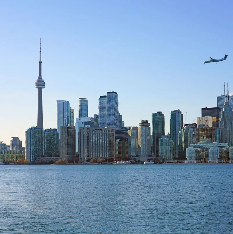 Airplane flying over toronto skyline