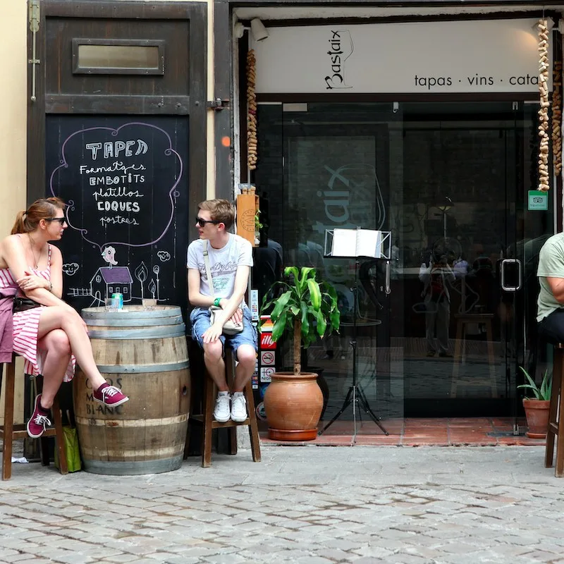 Tourists sitting outside at a cafe sidewalk in Barcelona, Spain.