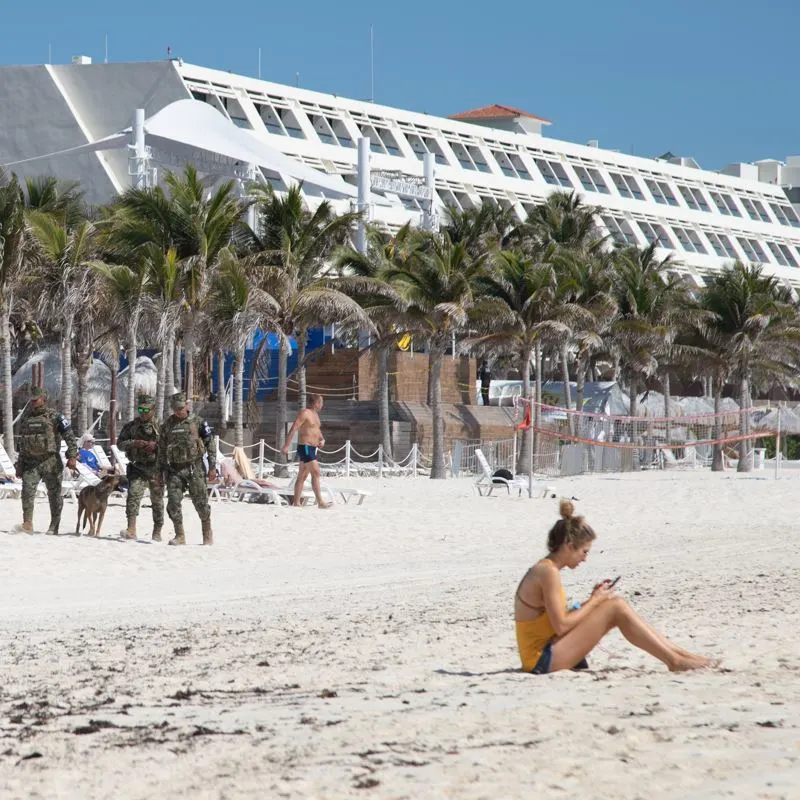 Police patrolling cancun beach with k9 unit